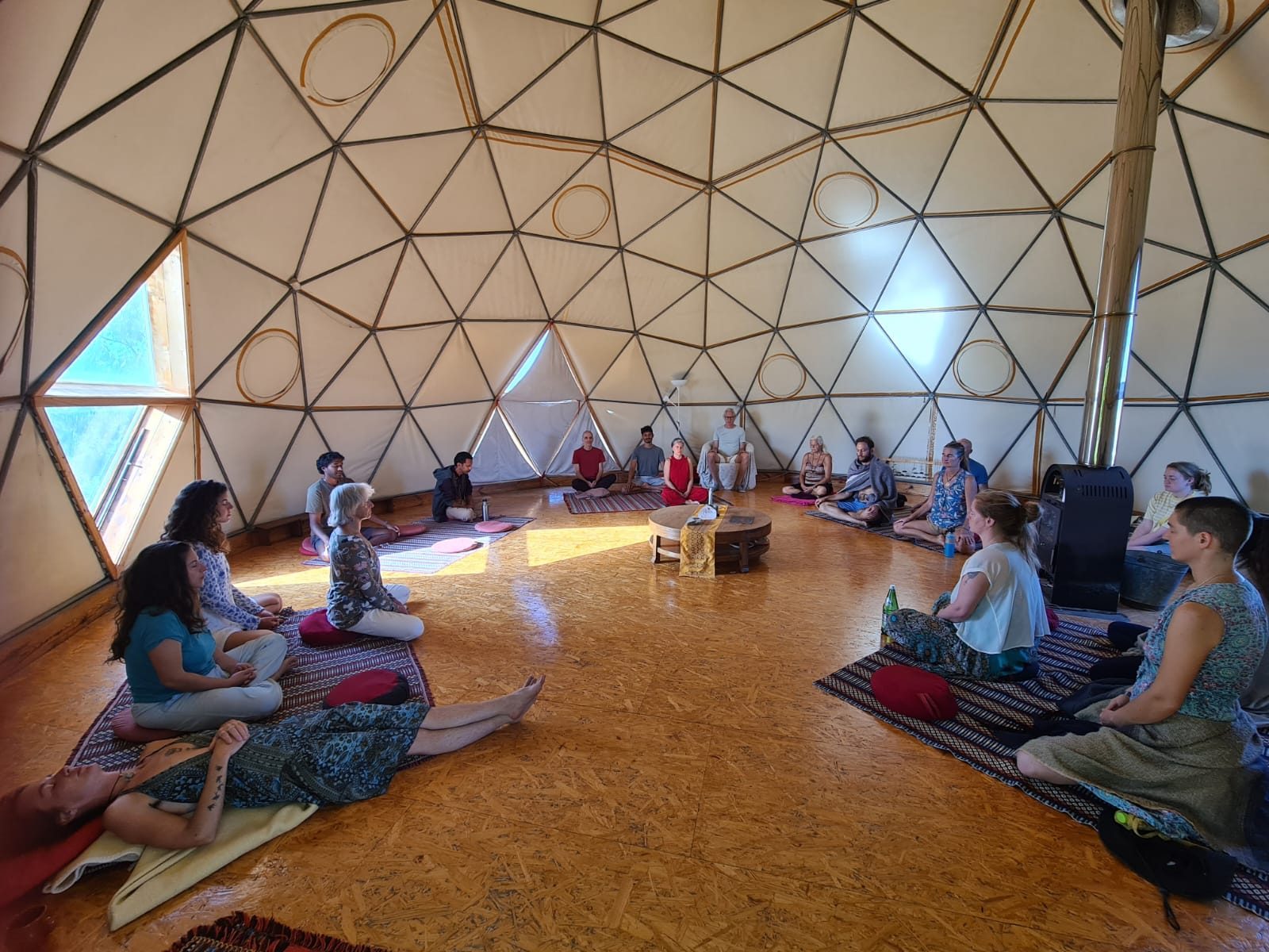 A circle of people meditating together in a domed room